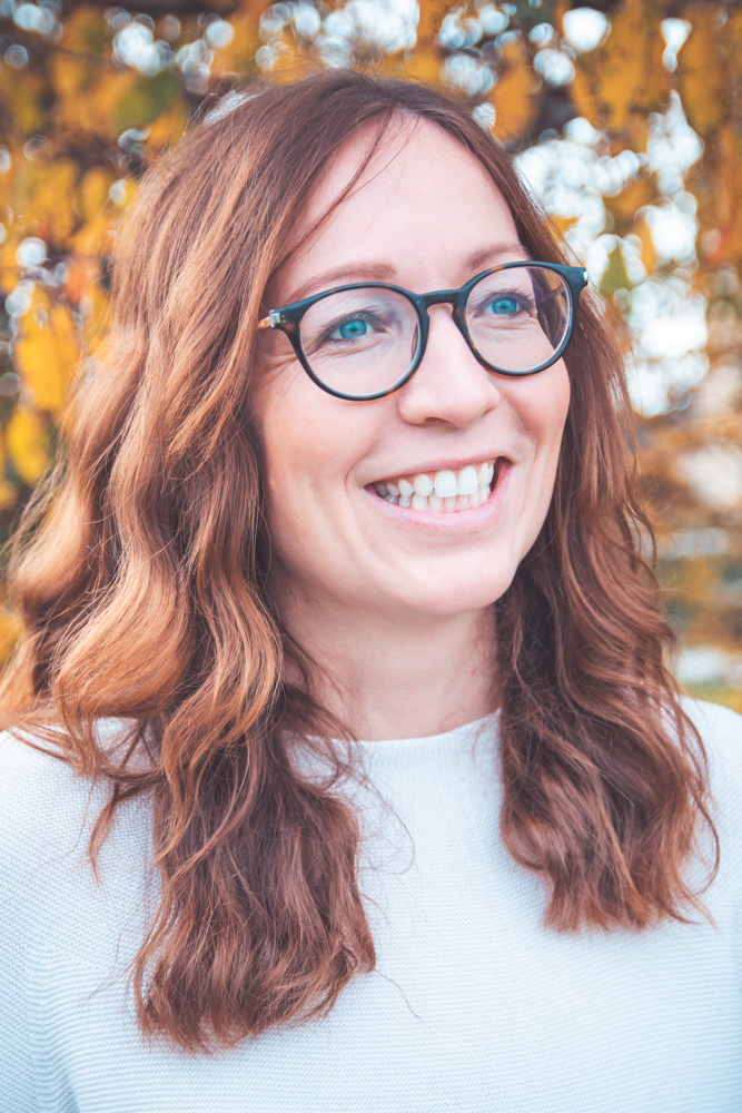 A couch sitting in a living room next to a plant